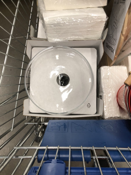 Ikea shopping cart containing shallow glass bowls
 for table decoration, and other items.