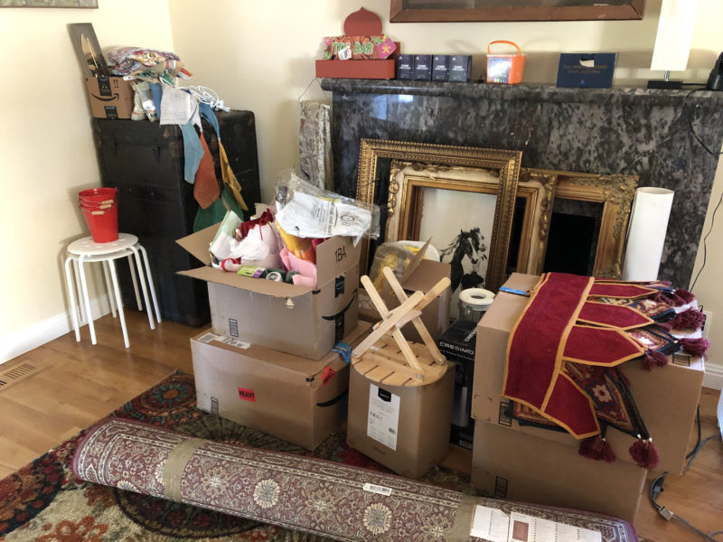 Fireplace area with accumulated wedding decor in boxes and not.