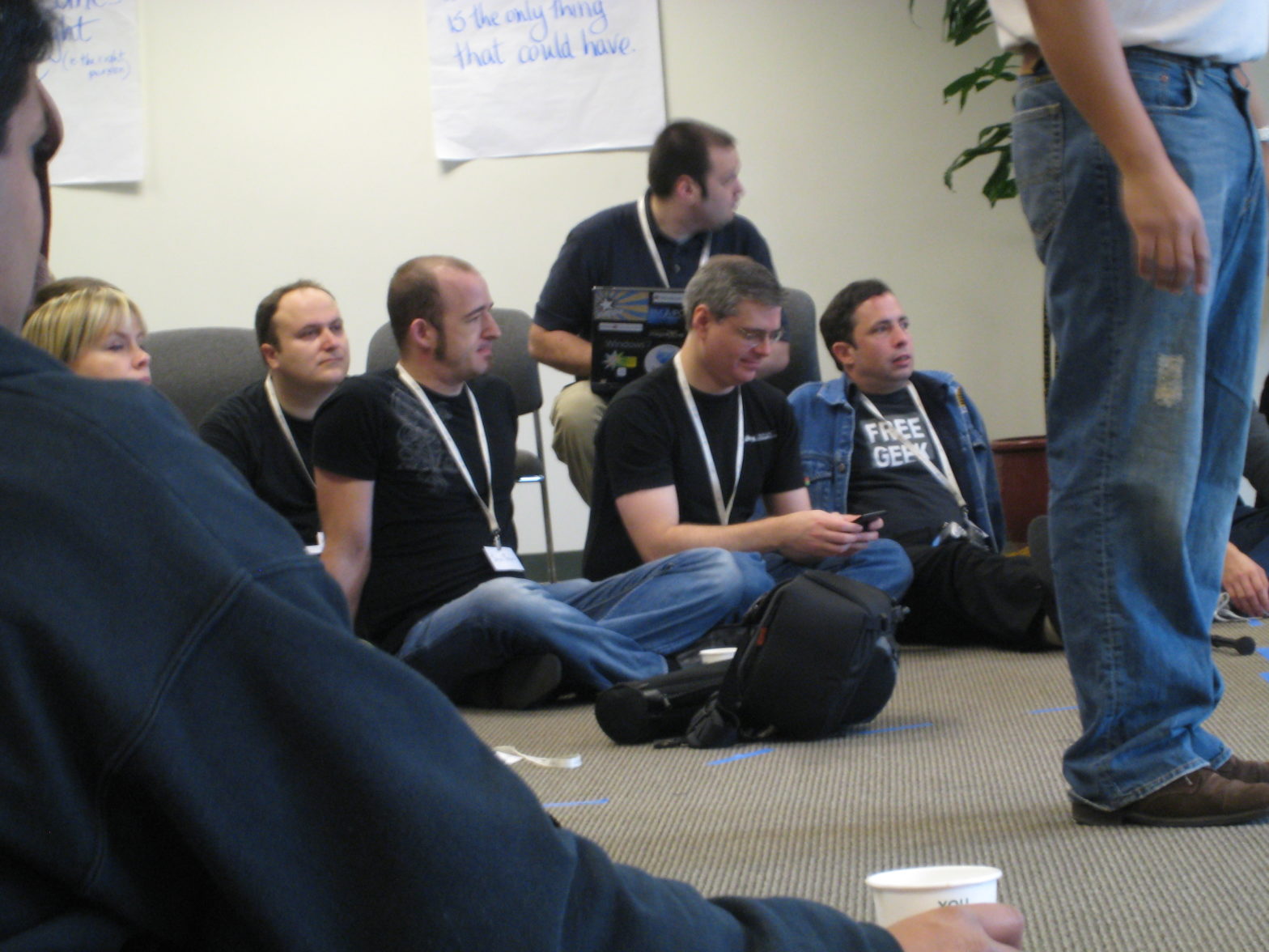 Jono Bacon and others seated on a conference room floor