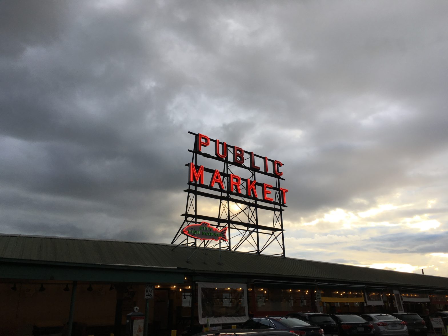 neon Public Market sign in Seattle, against a cloudy evening sky