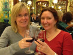 Deirdré and Robyn toasting at a restaurant in Paris