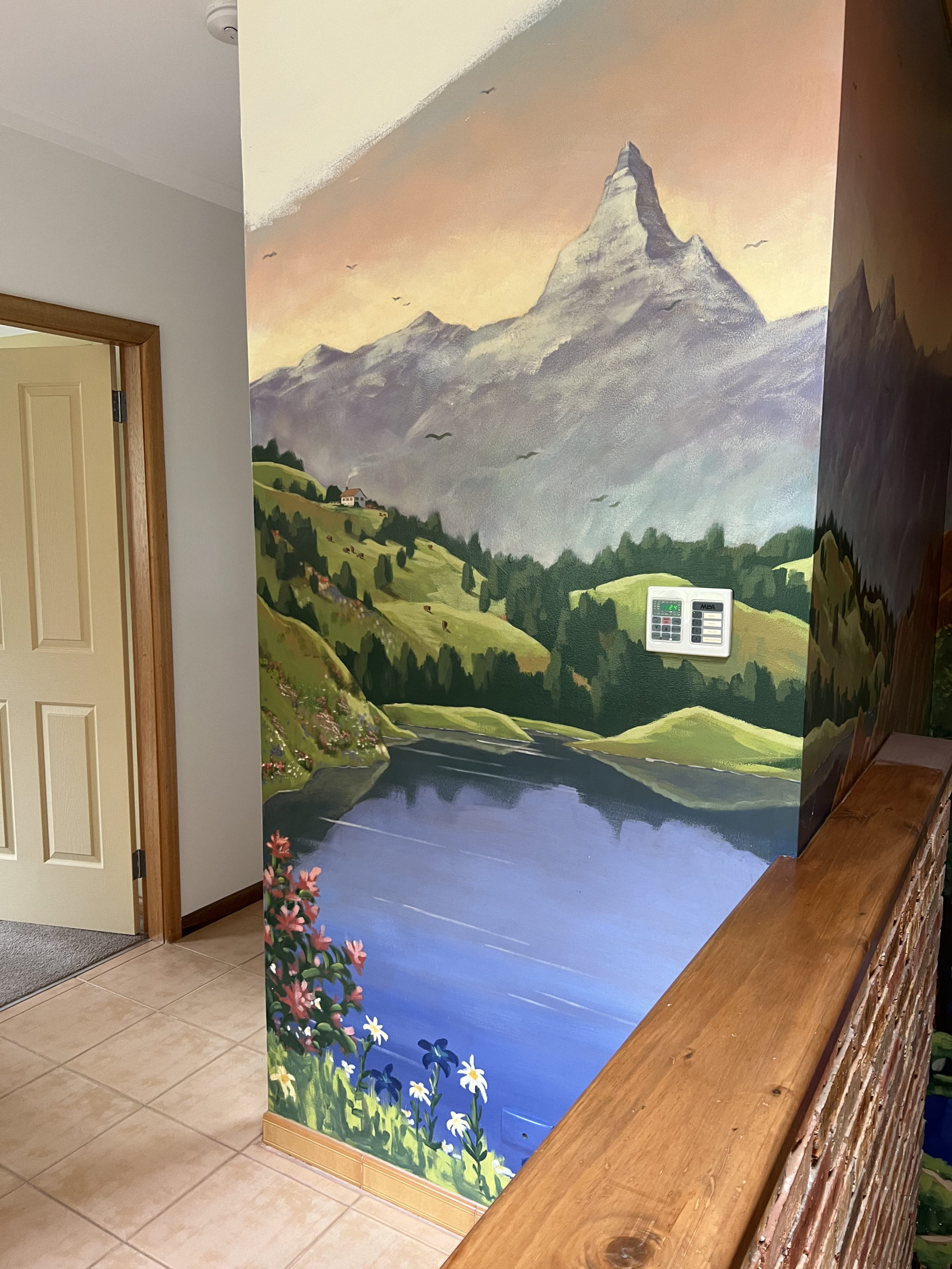 house interior decorated with murals of Switzerland - the Matterhorn, waterfall, lake