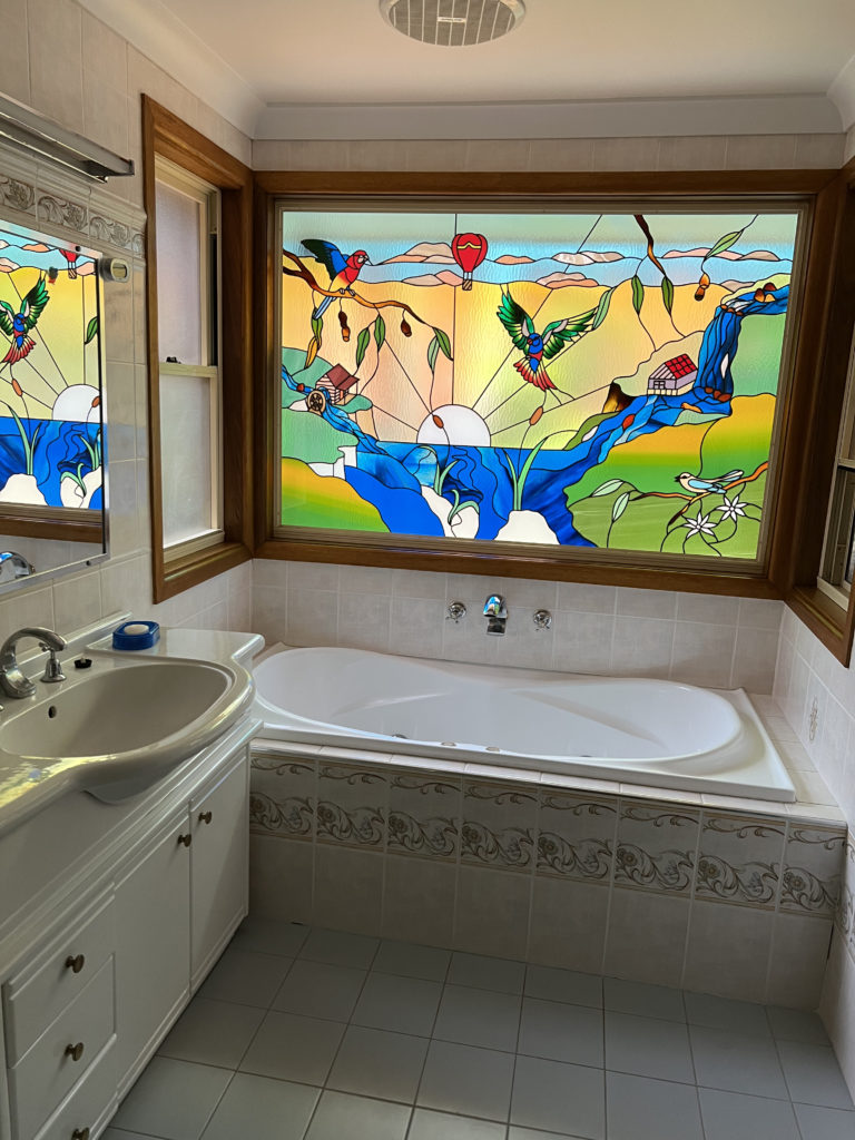stained glass window over a bathtub, with birds
