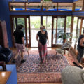 Brendan and 2 other people inside a house with dark blue walls and blue and red persian carpets