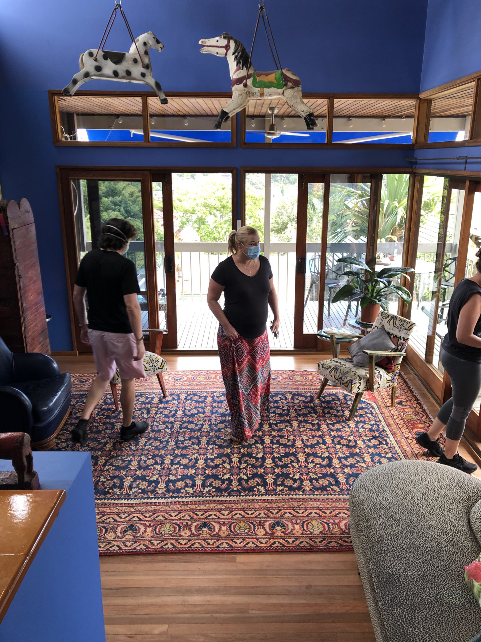 Brendan and 2 other people inside a house with dark blue walls and blue and red persian carpets