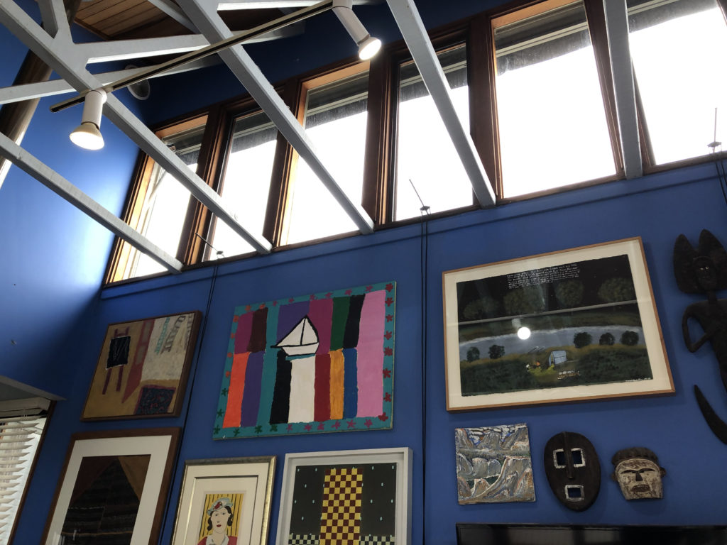view up to the high ceiling with high windows, blue walls, and vibrant paintings