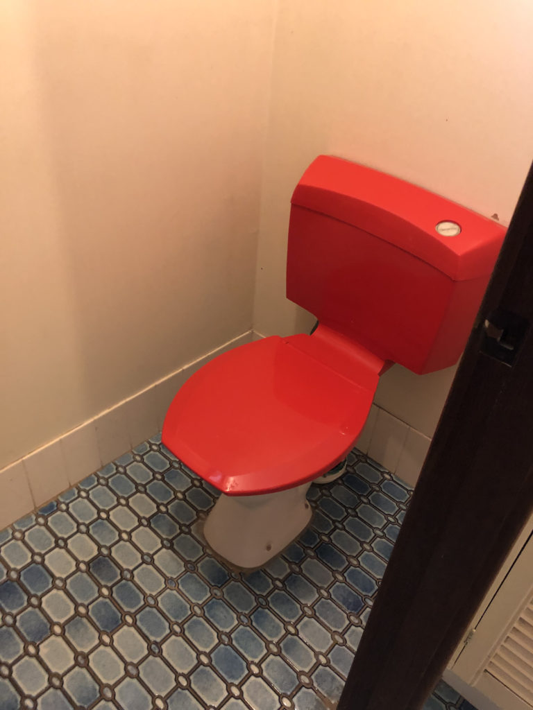 red plastic toilet tank and seat, vintage 1970s?