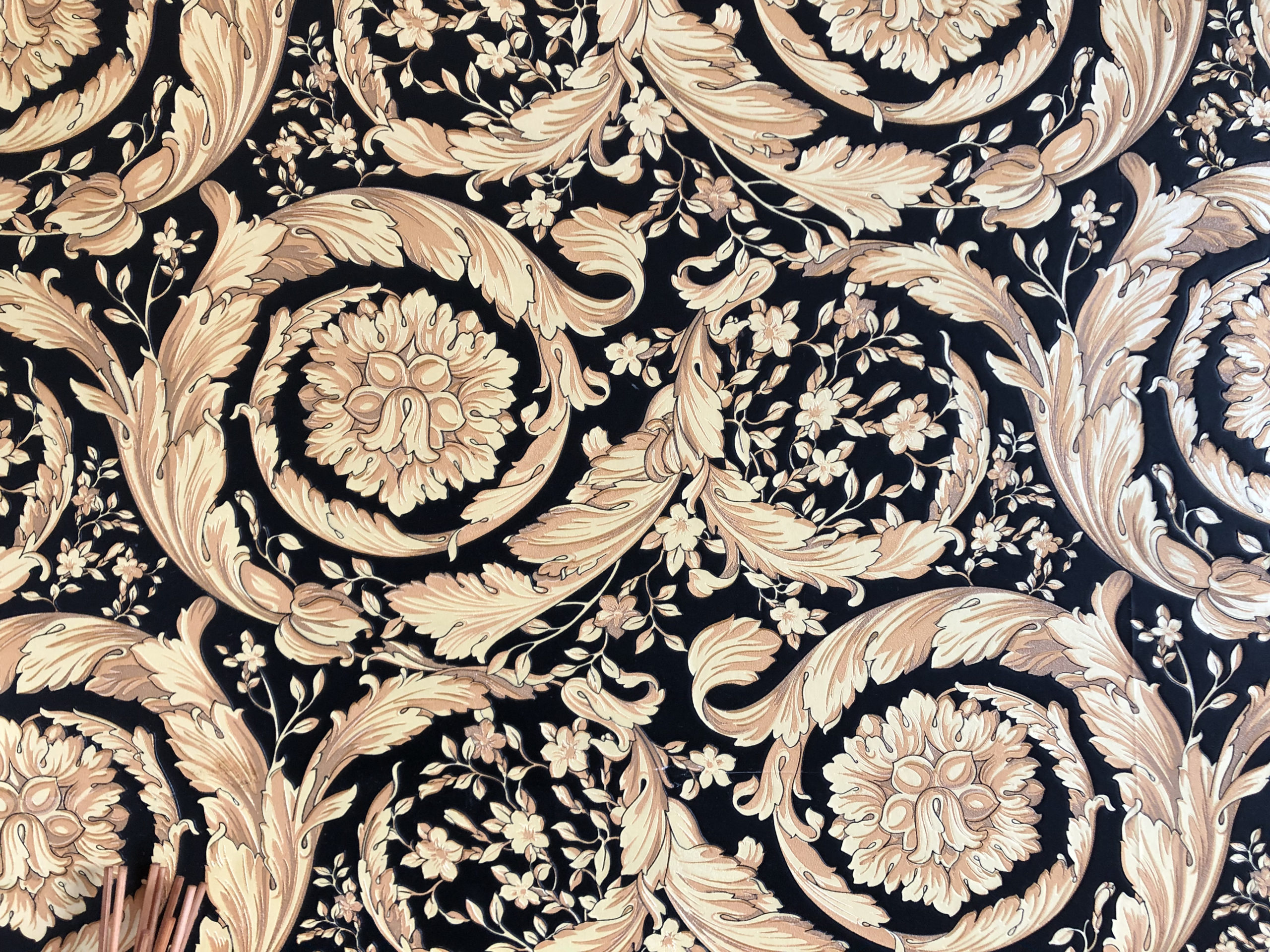 wallpaper: close-up of beige and cream antique floral design on dark blue

