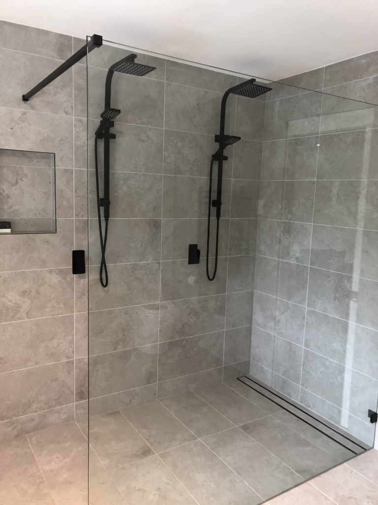 a shower enclosure with side-by-side shower heads