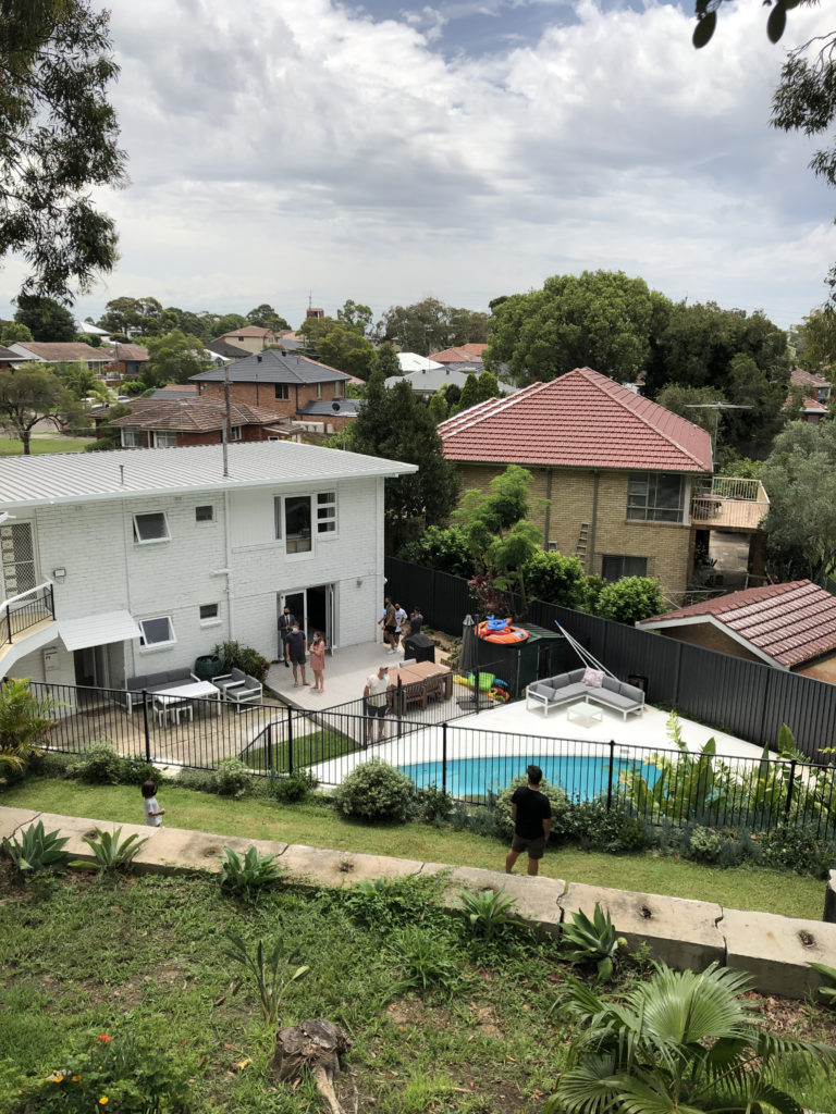 looking down a terraced hillside to a pool and house