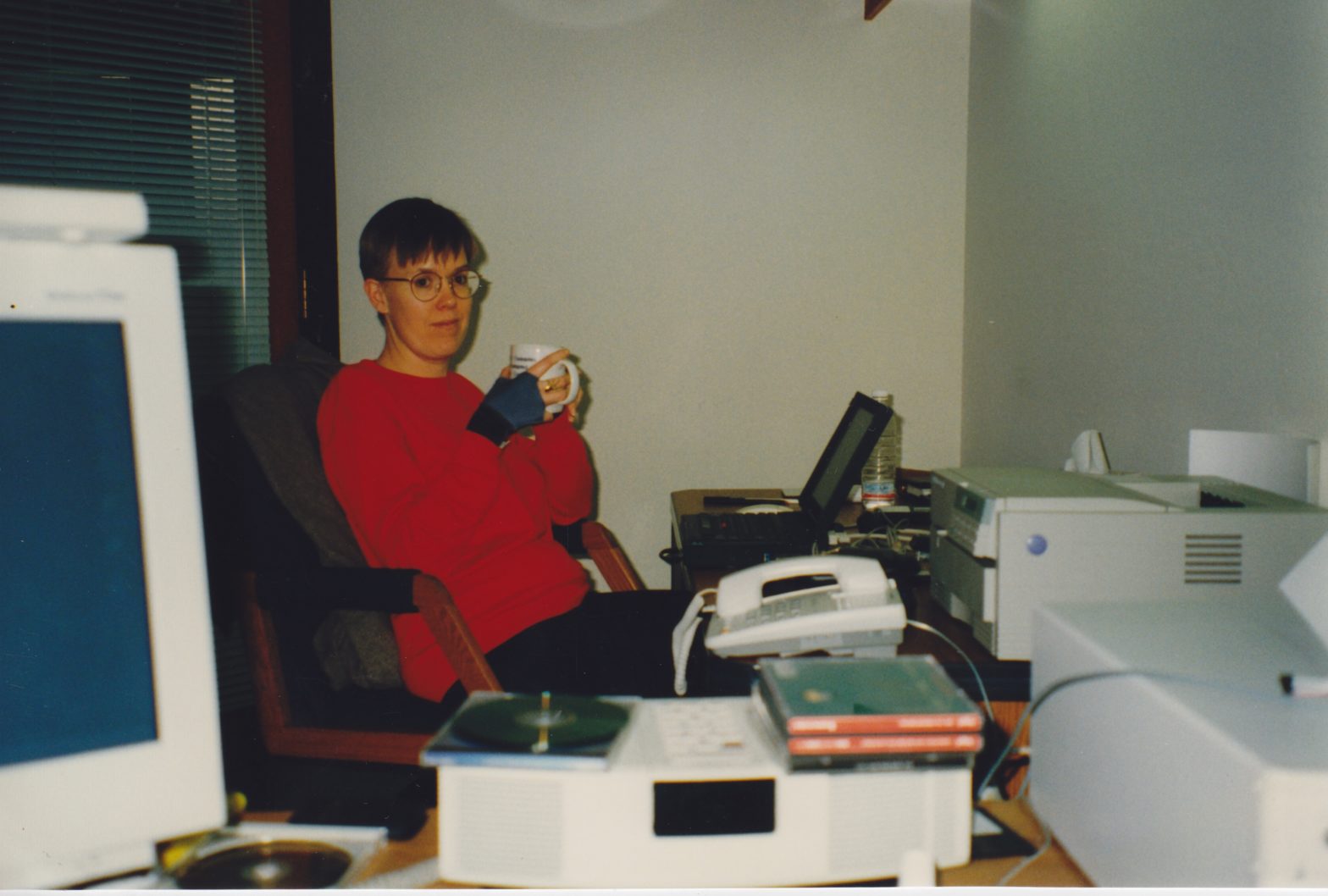 Deirdré at her desk at Incat Systems' Campbell CA office - I'm in the background wearing a red sweatshirt, surrounded by beige-colored electronics (CRT monitor, printer, office phone...)