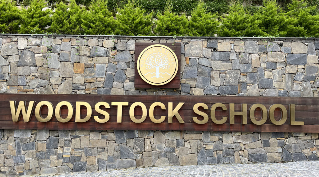 Woodstock School entrance gate sign with lyre tree logo