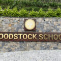 Woodstock School entrance gate sign with lyre tree logo